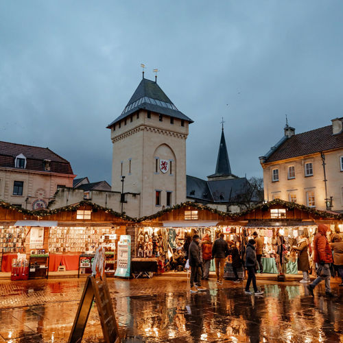 Kerstmarkt in Valkenburg met daarachter de Geulpoort in de avond