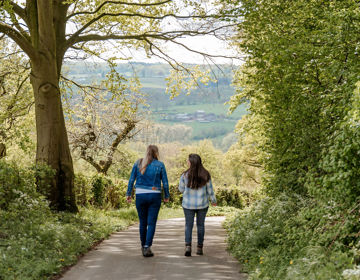 Twee jonge vrouwen wandelend over weg met uitzicht